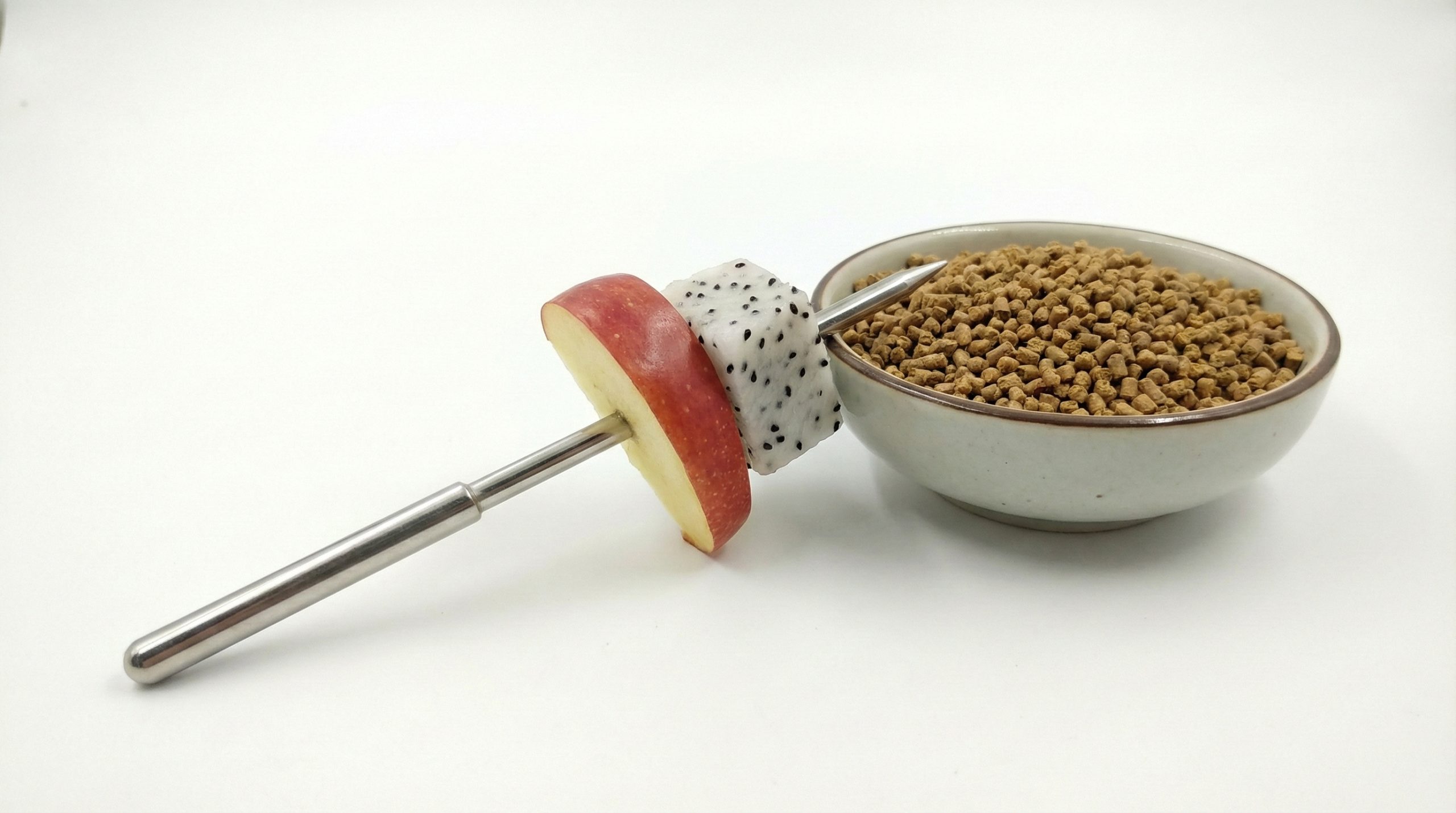 Hình ảnh một lát táo Mỹ mỏng và một góc thanh long được ghim gọn gàng trên xiên inox.